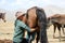 Song Kul lake, Kyrgystan, August 15 2018: Young Kyrgyz milks a horse mare