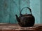 Sooty old teapot on old table in kitchen