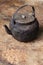 Sooty old teapot on old table in open kitchen