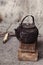 Sooty old teapot on small wooden bench in open kitchen