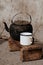 Sooty old teapot and white enamel mug on small wooden bench