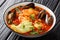 Sopa de Mariscos seafood soup with cod, shrimp, mussels, vegetables and avocado close-up in a bowl. Horizontal