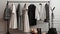 A sophisticated display of a white-gray-black coat and sweater on hangers in a high-end fashion store. These classic