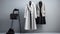 A sophisticated display of a white-gray-black coat and sweater on hangers in a high-end fashion store. These classic