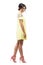 Sophisticated feminine young woman in short yellow evening dress walking and looking down