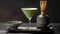 A sophisticated matcha martini stands tall, its frothy top complementing the traditional matcha tea set and bamboo whisk