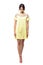 Sophisticated young runway fashion model in yellow dress walking and looking down.