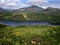 Sopochnoye lake view with flowers meadow on sunny day. Iturup, Kuril Islands, Russia.