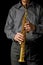 Soprano saxophone in hands on a black background