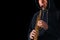 Soprano saxophone in the hands of a guy on a black background