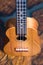 Soprano ukulele - small light brown instrument on beautiful wooden table