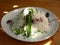 Sopsky salad of fresh vegetables on a plate and cheese on the surface