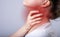 Sore throat, pain or ache in neck closeup. Person holding thyroid inflammation