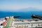 Sorrento, Italy - June 5, 2019: A beach with sunbathers in Sorrento, with background of unfocused view of Vesuvius volcano