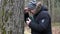 Sorrowful man with Bible and rosary crying near tree