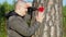 Sorrowful man holding knife and fabric heart near the tree