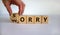 Sorry to worry. Hand turns a cube and changes the word `worry` to `sorry`. Beautiful white background. Business concept, copy