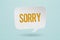 sorry word on white bubble speech paper cut with grunge blue pastel background