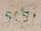 SOS inscription and woman sunbathes on the beach nearby. Environmental problem. Ecology concept. Plastic on the beach