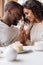 Soulful smiling African American couple touching hands in the cafe