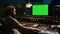 Sound designer watches online tutorials via greenscreen monitor