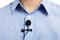 Sound recording concept - close up of small lavalier clip-on microphone on blue male shirt