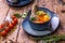 Soup in the assortment, tomatoes, spices on a brown wooden background