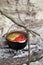 Soup cooking in sooty cauldron on campfire