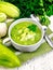 Soup cucumber with parsley in white bowl on light board