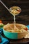 Soup with matzo dumplings and chicken with carrots and tomatoes is poured into bowl with ladle. Healthy Food for Passover