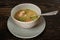 Soup with meat and herbs in a gray bowl on a dark wooden table. Chikhirtma Georgian dish