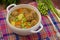 Soup with meatballs, carrots and peas. Wooden rustic background. Close-up