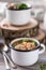 Soup with meatballs in metal mugs on wooden background