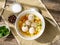 soup with meatballs in white plate on old wooden rustic grey table, top view, sunlight, deep shadow