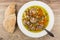 Soup with mushrooms and spoon in plate, pieces of pita