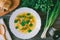 Soup with noodles and greens, corn bread and bunches of onions, parsley, and dill. top view closeup