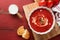 Soup. Tomato cream soup or gazpacho with herbs, seasonings, cherry tomato and parsley in white bowl on old red wooden background