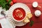 Soup. Tomato cream soup or gazpacho with herbs, seasonings, cherry tomato and parsley in white bowl on old red wooden background.