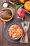 Soup with turkey, pasta, carrot, celery, tomato and cannellini beans, garnished with parmesan cheese, on the table with autumn