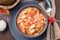 Soup with turkey, pasta, carrot, celery, tomato and cannellini beans, garnished with parmesan cheese, on the table with autumn