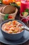 Soup with turkey, pasta, carrot, celery, tomato and cannellini beans, garnished with parmesan cheese, on the table with autumn