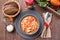 Soup with turkey, pasta, carrot, celery, tomato and cannellini beans, garnished with parmesan cheese, on the table with autumn