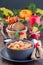 Soup with turkey, pasta, carrot, celery, tomato and cannellini beans on the table with autumn decoration, reflecting the US