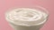 sour cream in a bowl. yogurt on a pink background. fermented milk products close-up.