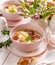 The Sour soup made of rye flour with sausage and eggs served in pink ceramic bowl. Traditional easter polish sour rye soup