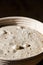 Sourdough bread proofing in a basket with visible gas bubbles. Homemade baking