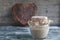 Sourdough on whole grain flour in glass jar and rye bread in shape heart, yeast-free organic bread, horizontal frame