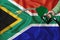 SOUTH AFRICA flag Close-up shot on waving background texture with Fuel pump nozzle in hand. The concept of design solutions. 3d