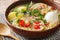 South American Caldo de Gallina chicken noodle soup with boiled egg and herbs close-up in a plate. horizontal