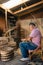 South American craftsman sitting on his chair while weaving wicker basket